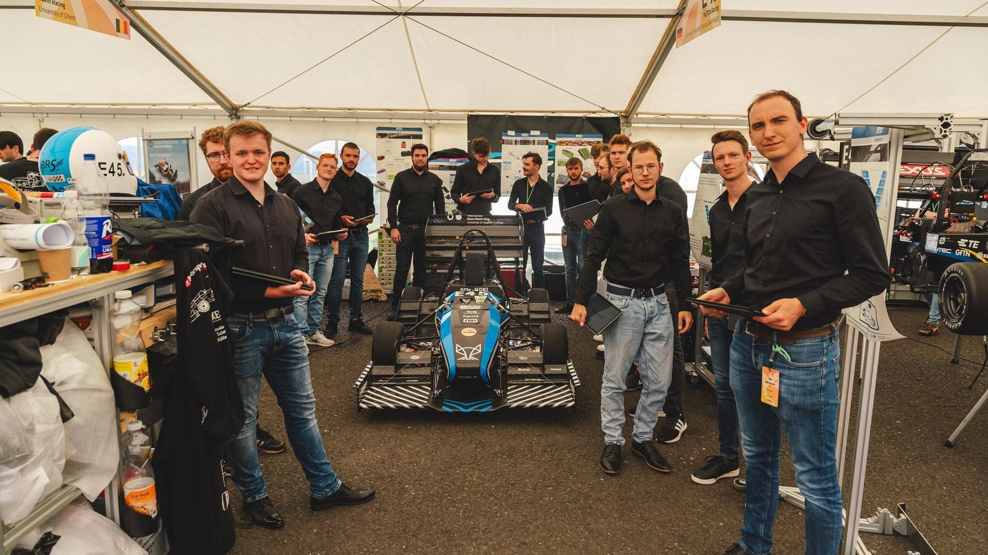 Das Motorsportteam der Hochschule Bonn Rhein-Sieg steht um das Fahrzeug herum.