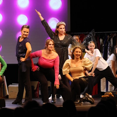 Junge Tänzerinnen posieren auf der Bühne in Formation.