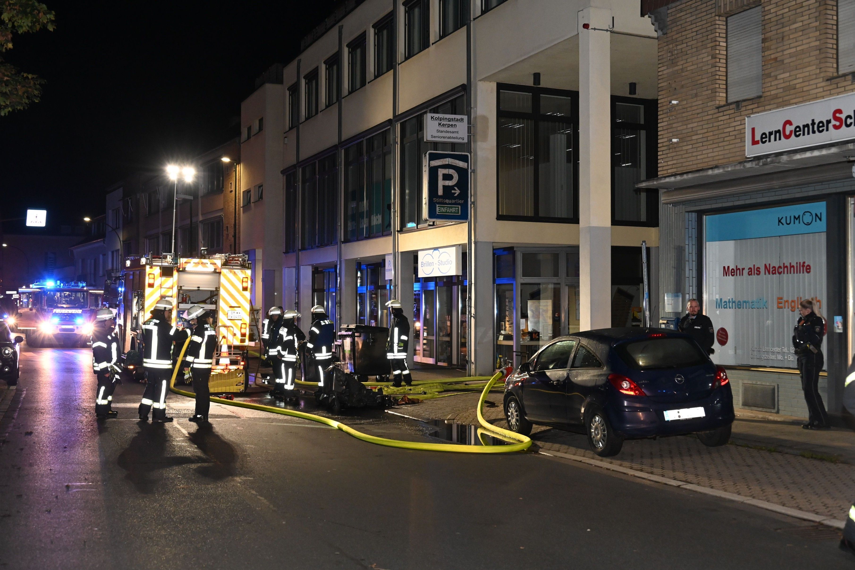 Auf dem Foto sind Feuerwehrleute vor dem Eingang zur Tiefgarage zu sehen.