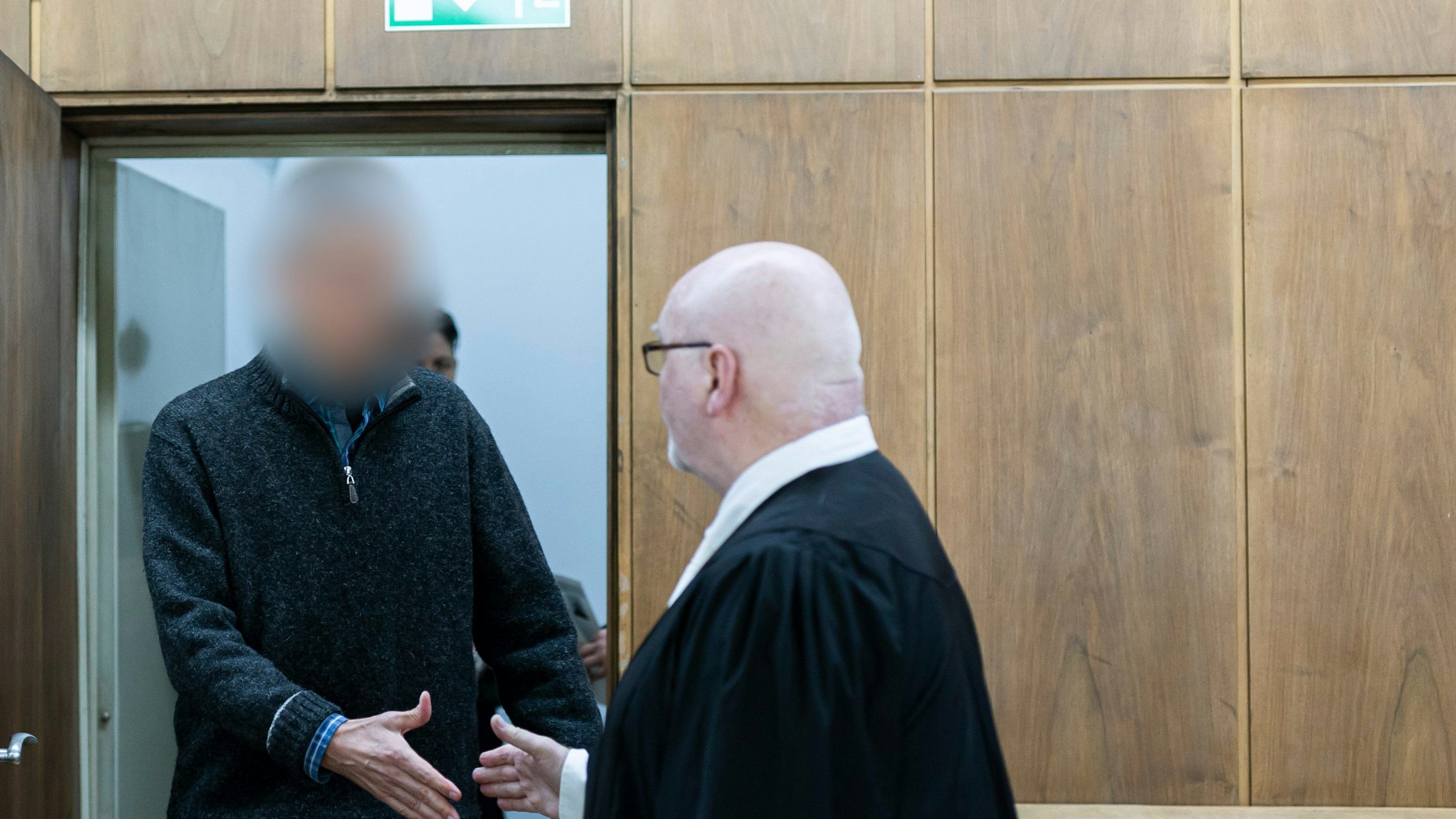 Der Angeklagte (l) kommt vor Verhandlungsbeginn in einen Gerichtssaal im Landgericht Hannover. Daneben steht sein Anwalt Matthias Waldraff (r).