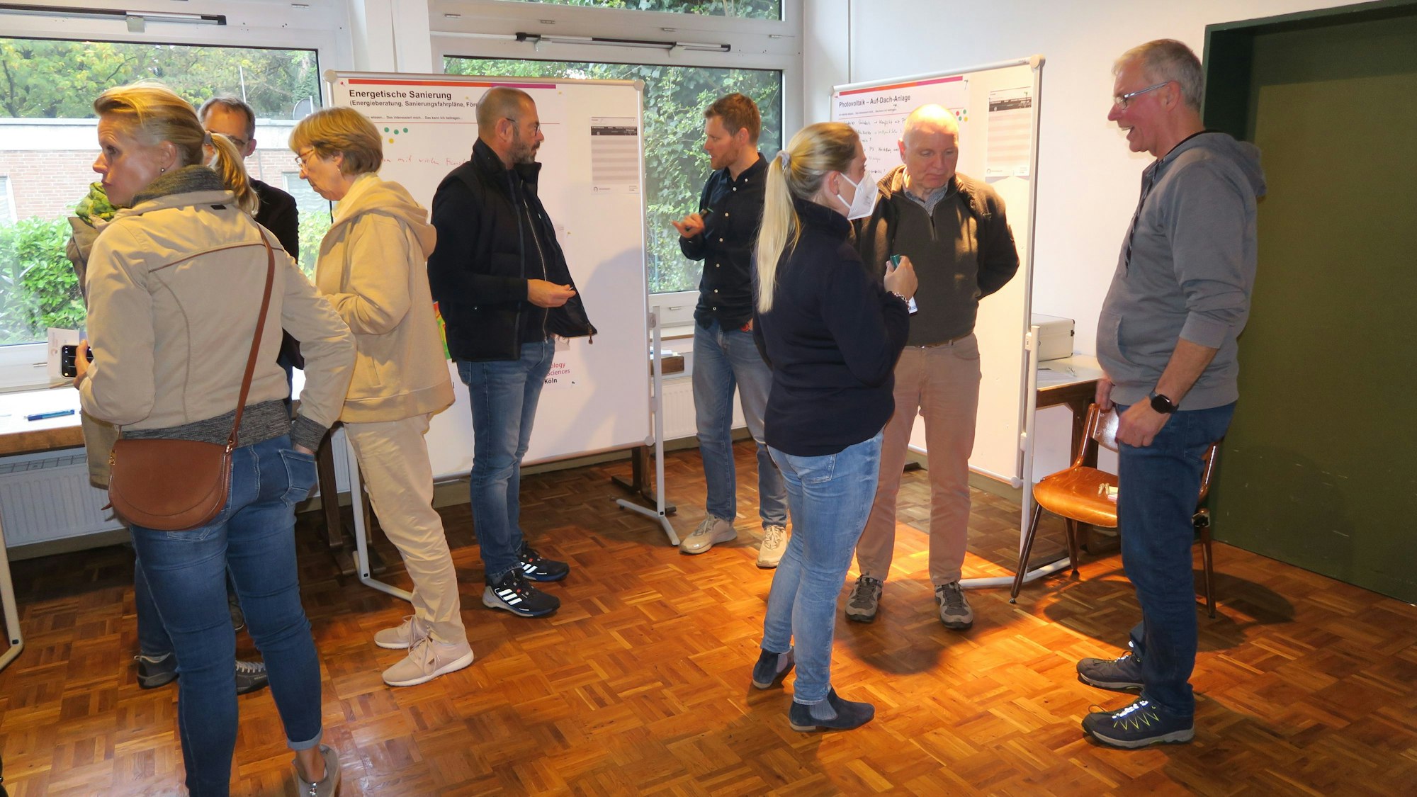 Menschen stehen in einem Raum und besprechen sich.