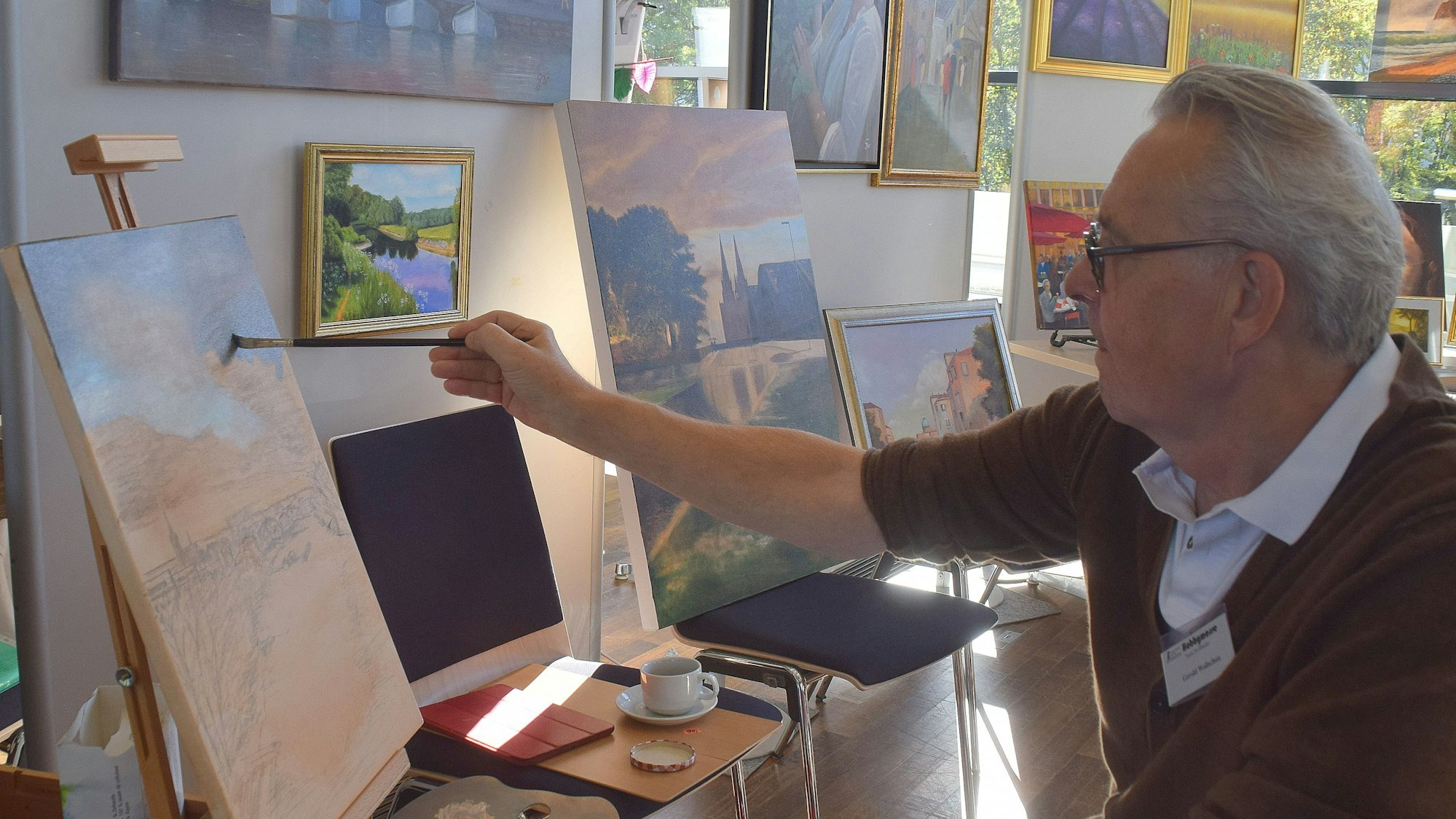 23. Oktober 2023. Bornheim. Gerold Wollschon brachte sich selbst das Malen bei und war ebenfalls auf der Hobbymesse des Seniorenbeirates dabei. Foto: Frank Engel-Strebel