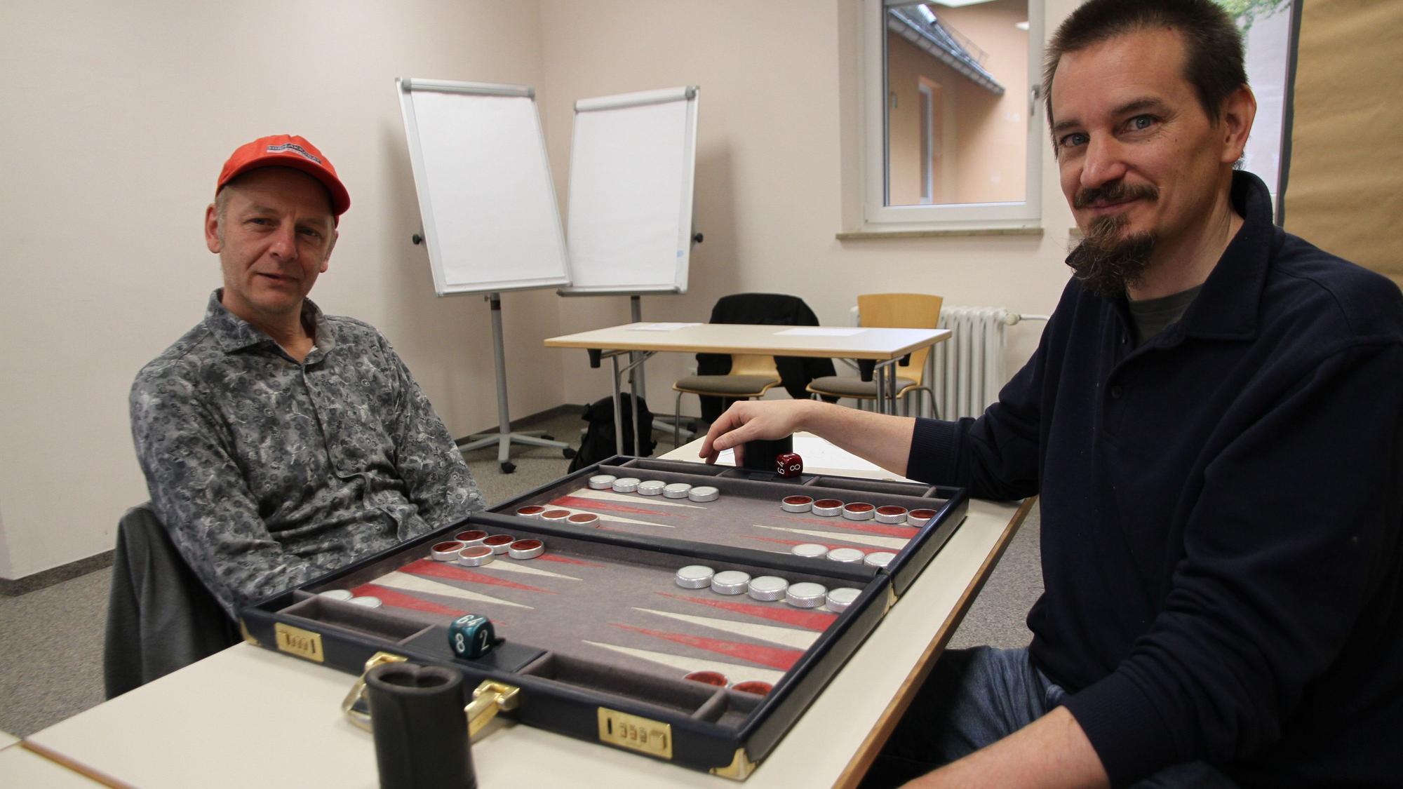Zwei Spieler an einem Backgammon-Brett