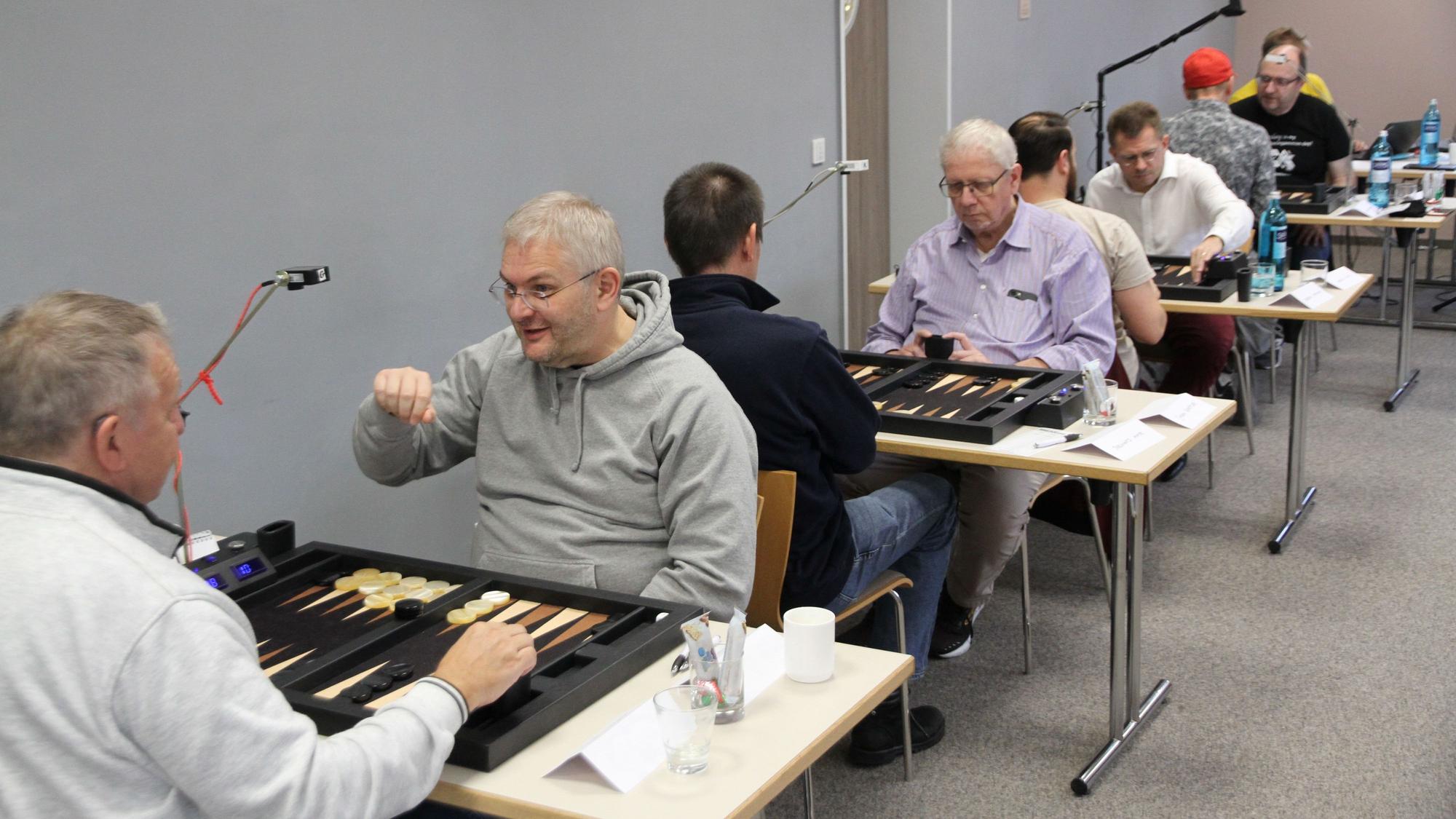 Spieler an Tischen bei einem Backgammon-Turnier