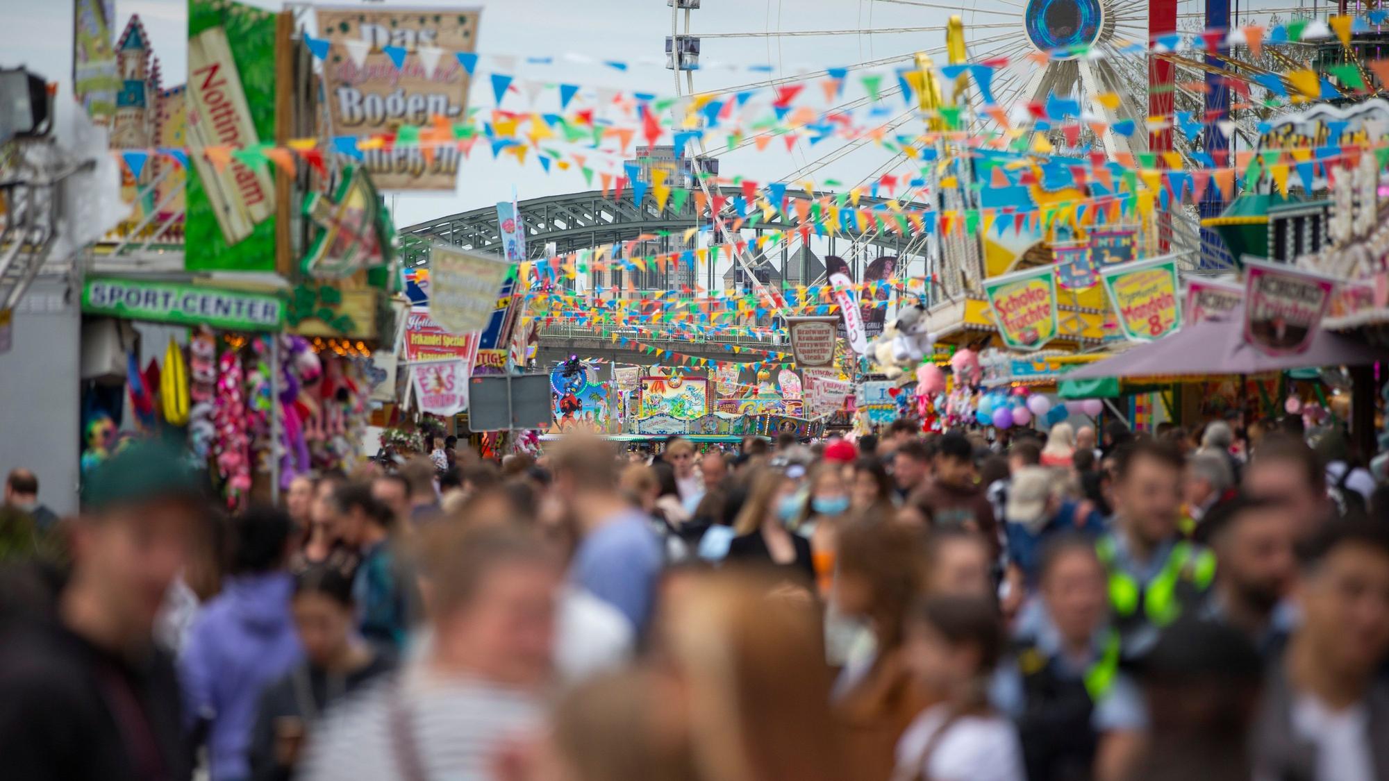 Menschen drängen sich auf einer Kirmes.