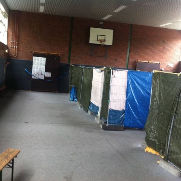 In einer Turnhalle sind provisorische Trennwände aufgestellt.