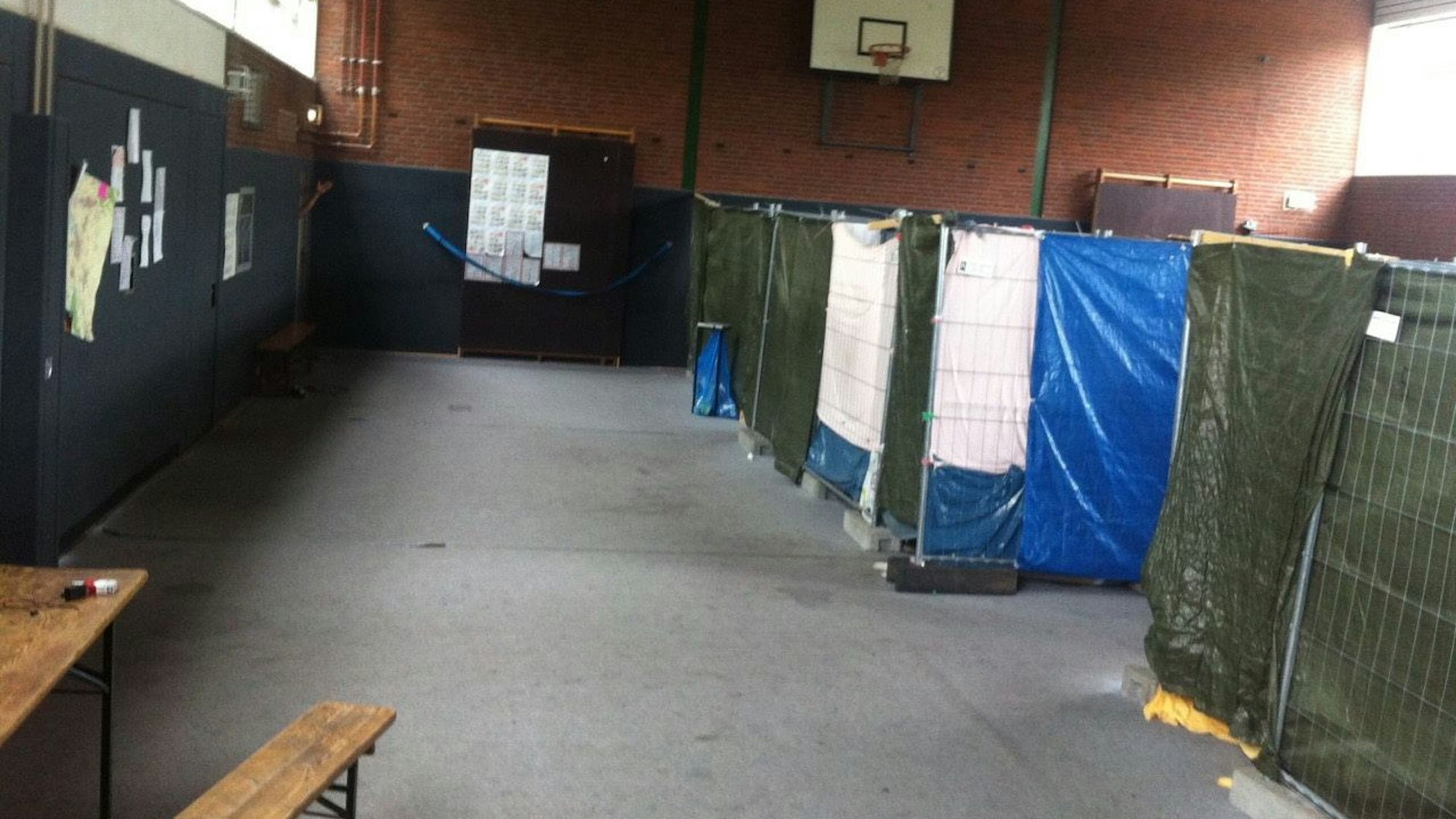 In einer Turnhalle sind provisorische Trennwände aufgestellt.