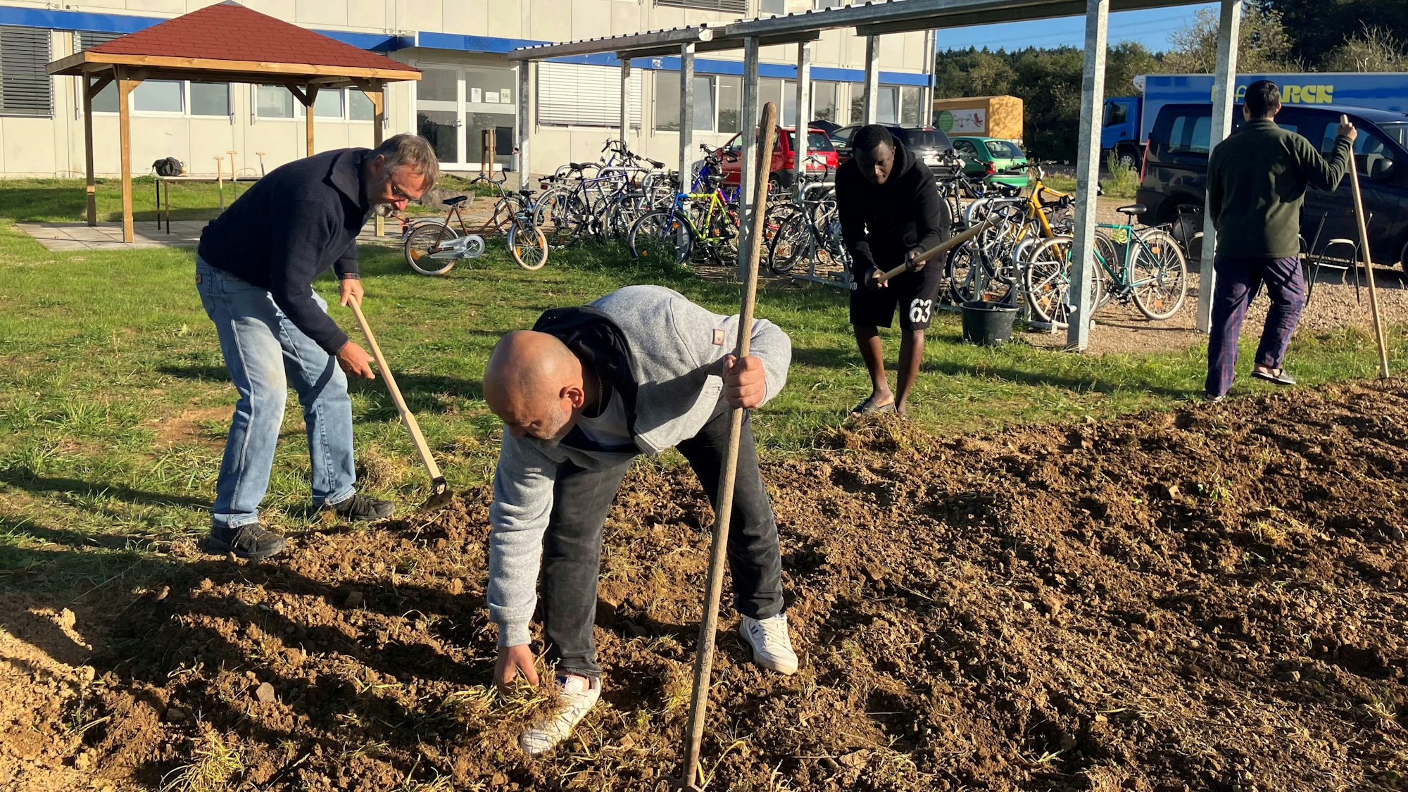 Gemeinsam legen Geflüchtete und Wachtberger Ehrenamtler in Villip ein Beet an.