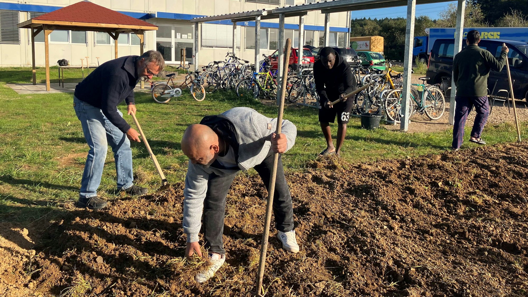 Gemeinsam legen Geflüchtete und Wachtberger Ehrenamtler in Villip ein Beet an.