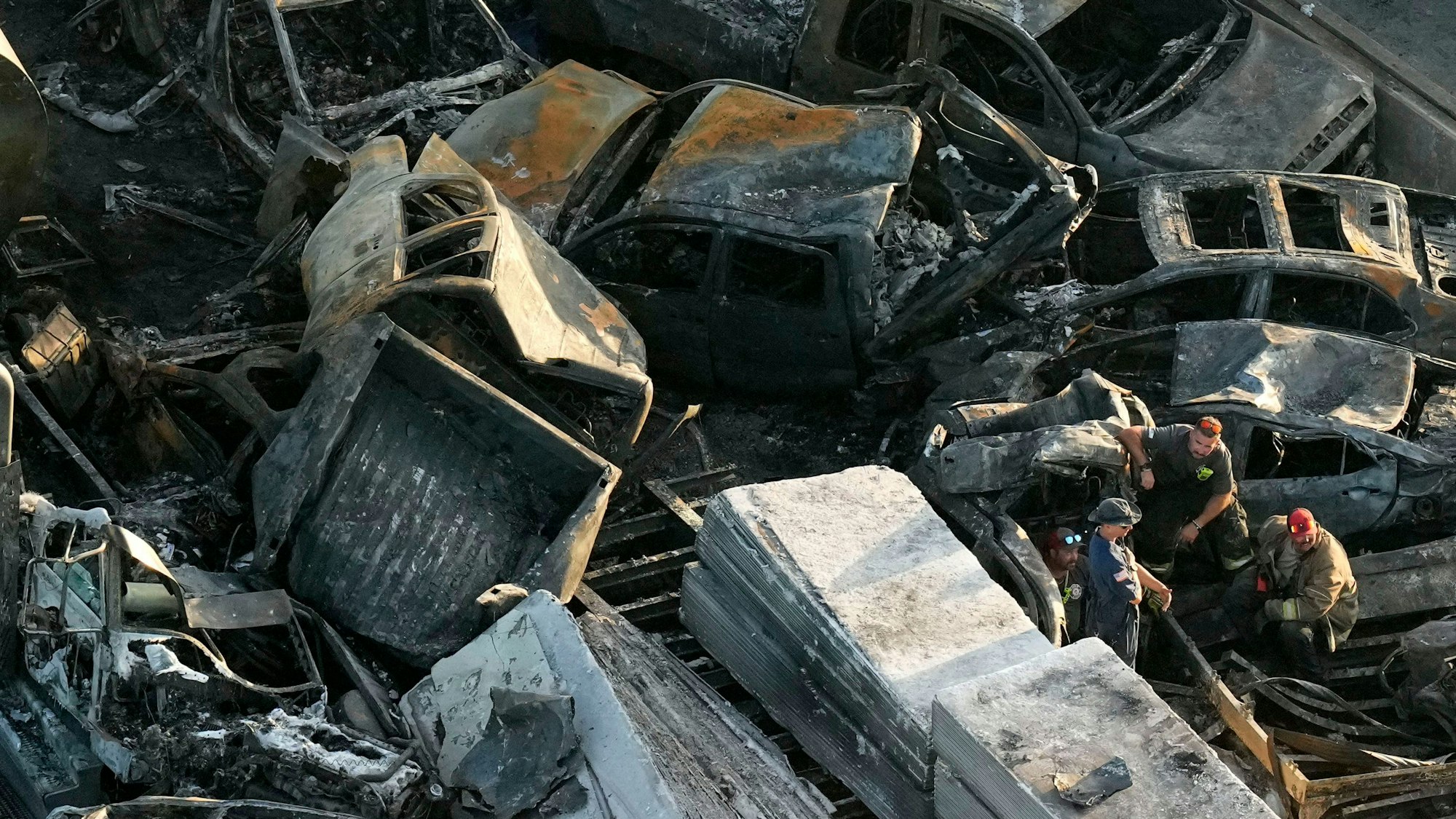 Einsatzkräfte sind bei den Wrackteilen nach einer Massenkarambolage auf der I-55 in Manchac, Laos, am Montag, 23. Oktober 2023, zu sehen. Ein sogenannter „Super Fog“ aus Rauch von Sumpfbränden in Süd-Louisiana und dichtem Morgennebel verursachte mehrere Verkehrsunfälle mit zahlreichen Fahrzeugen.