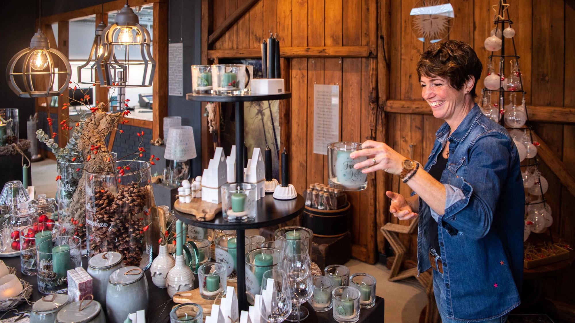 Das Bild zeigt Kerstin Wexel, wie sie ein Deko-Element aus Glas in die Ausstellung stellt.