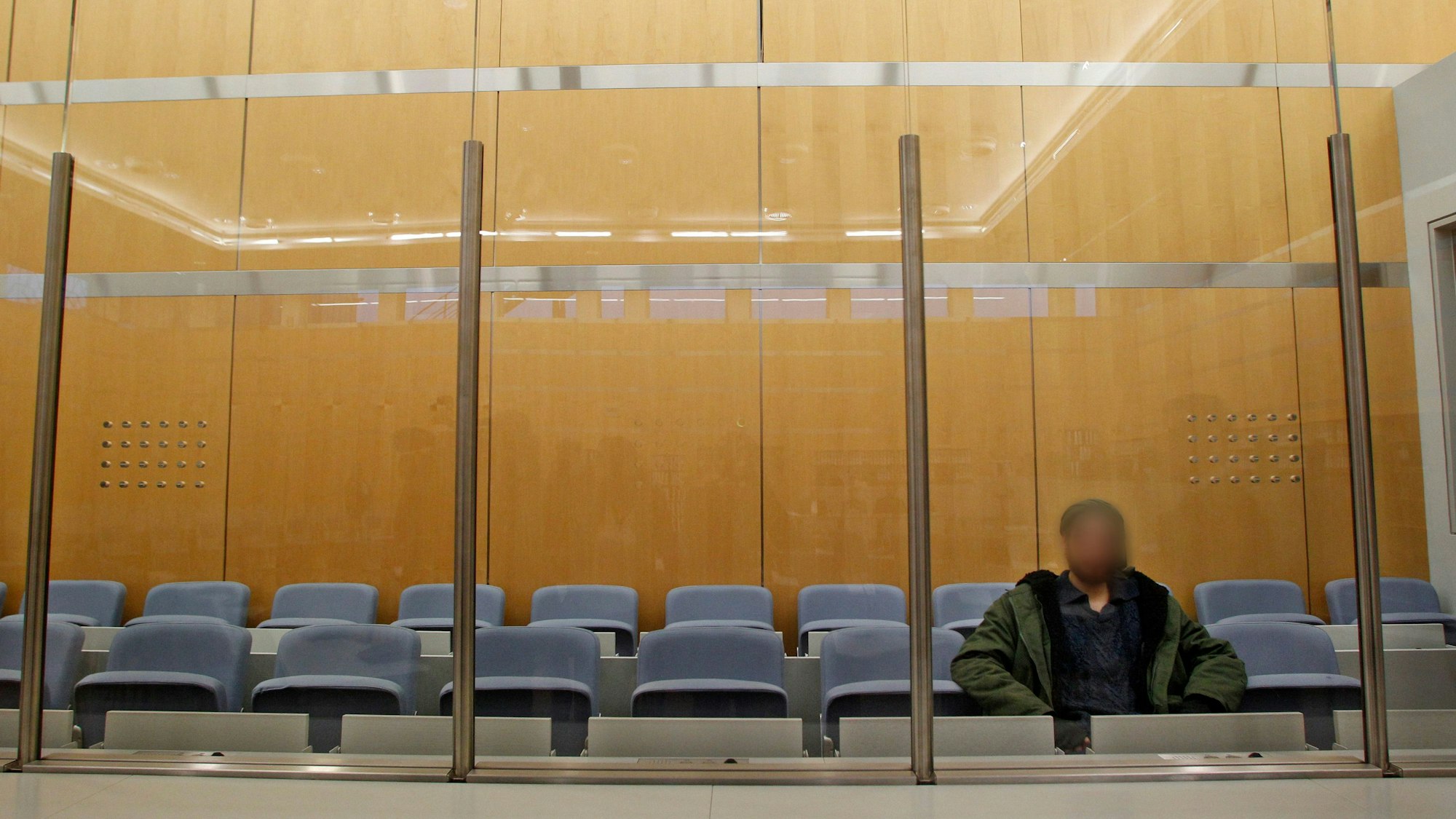 Düsseldorf: Der Angeklagte wartet hinter einer Sicherheitsscheibe vor dem Oberlandesgericht auf den Prozessbeginn.