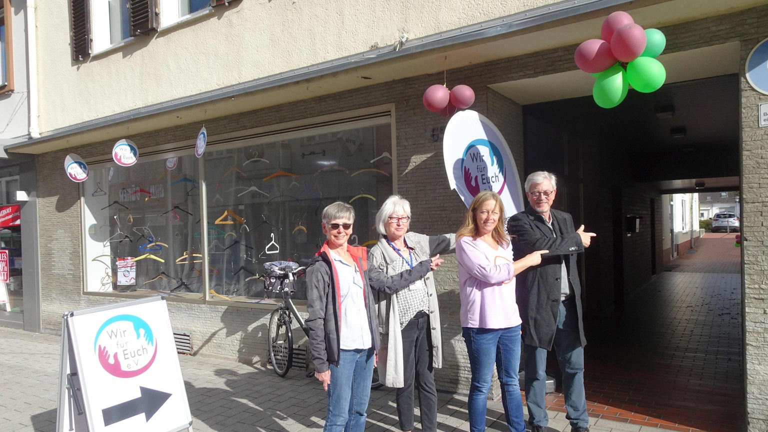 Der im Sept. 2022 gegründete Verein "Wir für euch" (WfE e.V.) ist umgezogen in neue Räume an der Hauptstraße 65 in Meckenheims Altstadt. Die Ehrenamtler Gerti Jansen, Gertrud Feller, Sandra Röttgen und Ralph von Hunnius (von links) deuten auf den Eingang des Ladenlokals, dass nicht direkt an der Hauptstraße liegt, sondern etwas versteckt hinter einer Fußgängerpassage.