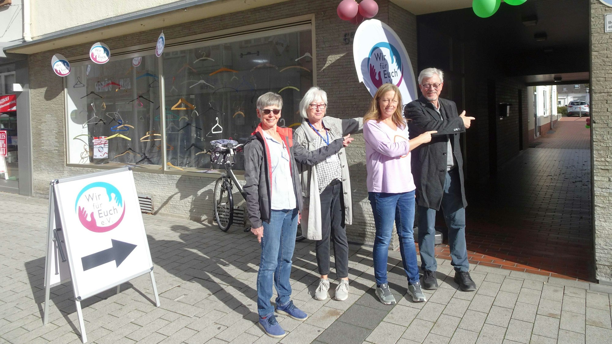 Der im Sept. 2022 gegründete Verein "Wir für euch" (WfE e.V.) ist umgezogen in neue Räume an der Hauptstraße 65 in Meckenheims Altstadt. Die Ehrenamtler Gerti Jansen, Gertrud Feller, Sandra Röttgen und Ralph von Hunnius (von links) deuten auf den Eingang des Ladenlokals, dass nicht direkt an der Hauptstraße liegt, sondern etwas versteckt hinter einer Fußgängerpassage.