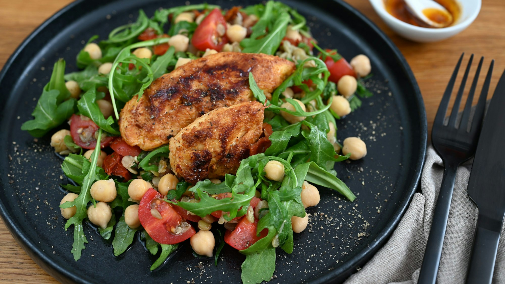 Der Hülsenfrüchte-Salat wird mit Hähnchenbrustfilets getoppt. Sie werden zuvor so mariniert, dass sie zugleich fruchtig, aber auch scharf sind.