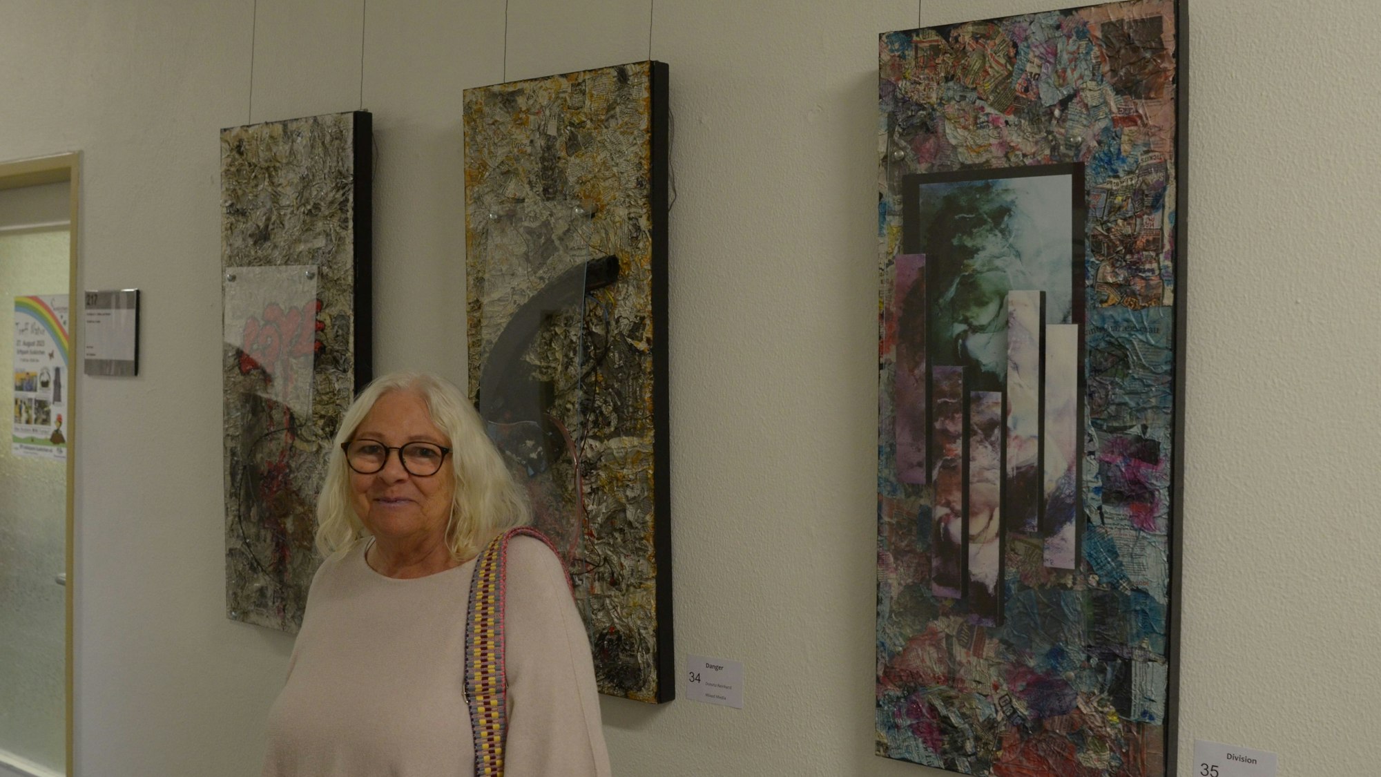 Die Künstlerin Donata Reinhard steht im Euskirchener Rathaus vor drei Werken, die sie dort ausstellt.