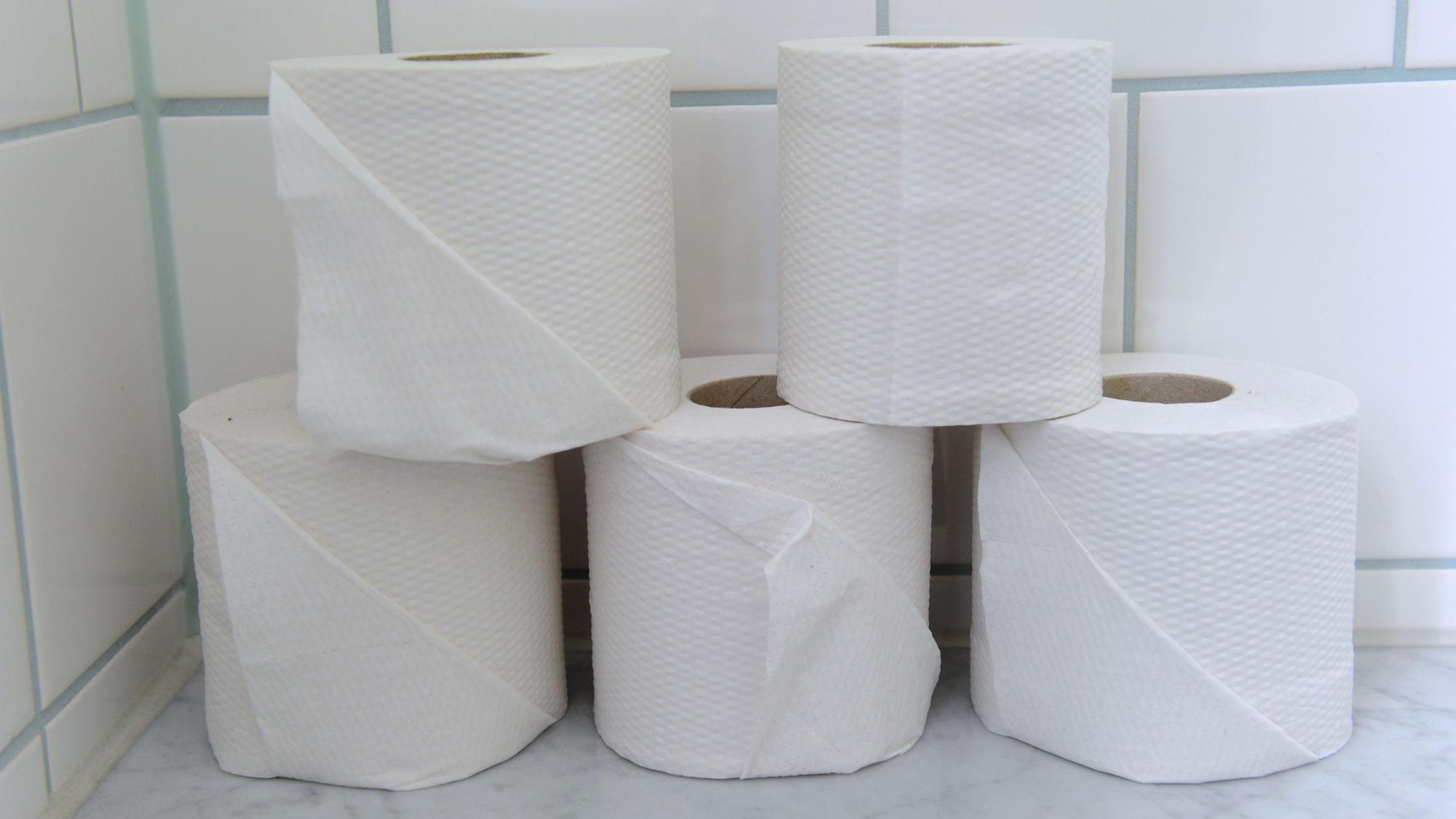 Fünf auseinandergestellte Rollen Toilettenpapier.