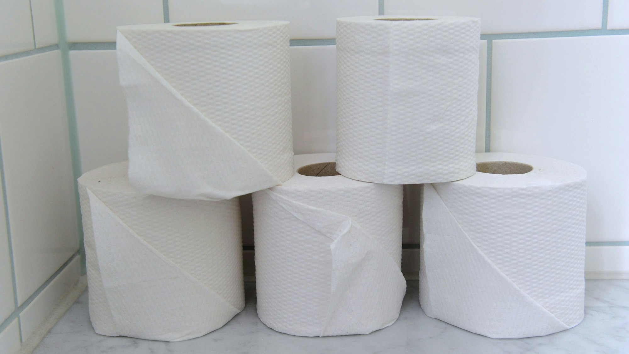 Fünf auseinandergestellte Rollen Toilettenpapier.