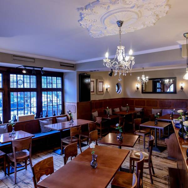 Holztische und Holzstühle mit Kronleuchter im Restaurant