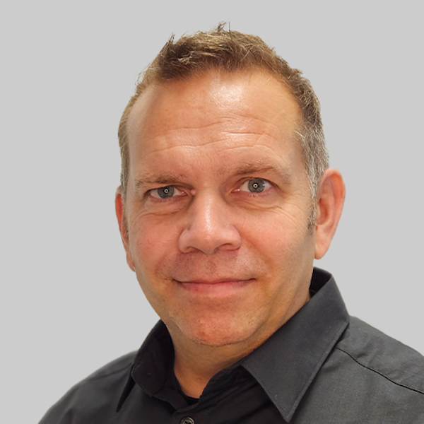 Zu sehen ist ein Strömungsretter der DLRG, der sich an einen Rettungsbalken im Wasser klammert.