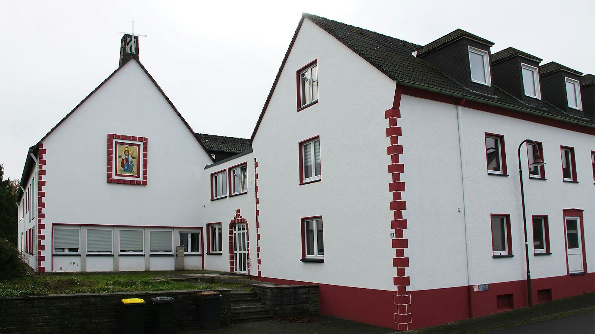Eine Außenansicht des rot-weiß getünchten Klostergebäudes.