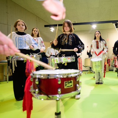 Schülerinne und Schüler klopfen auf Trommeln.
