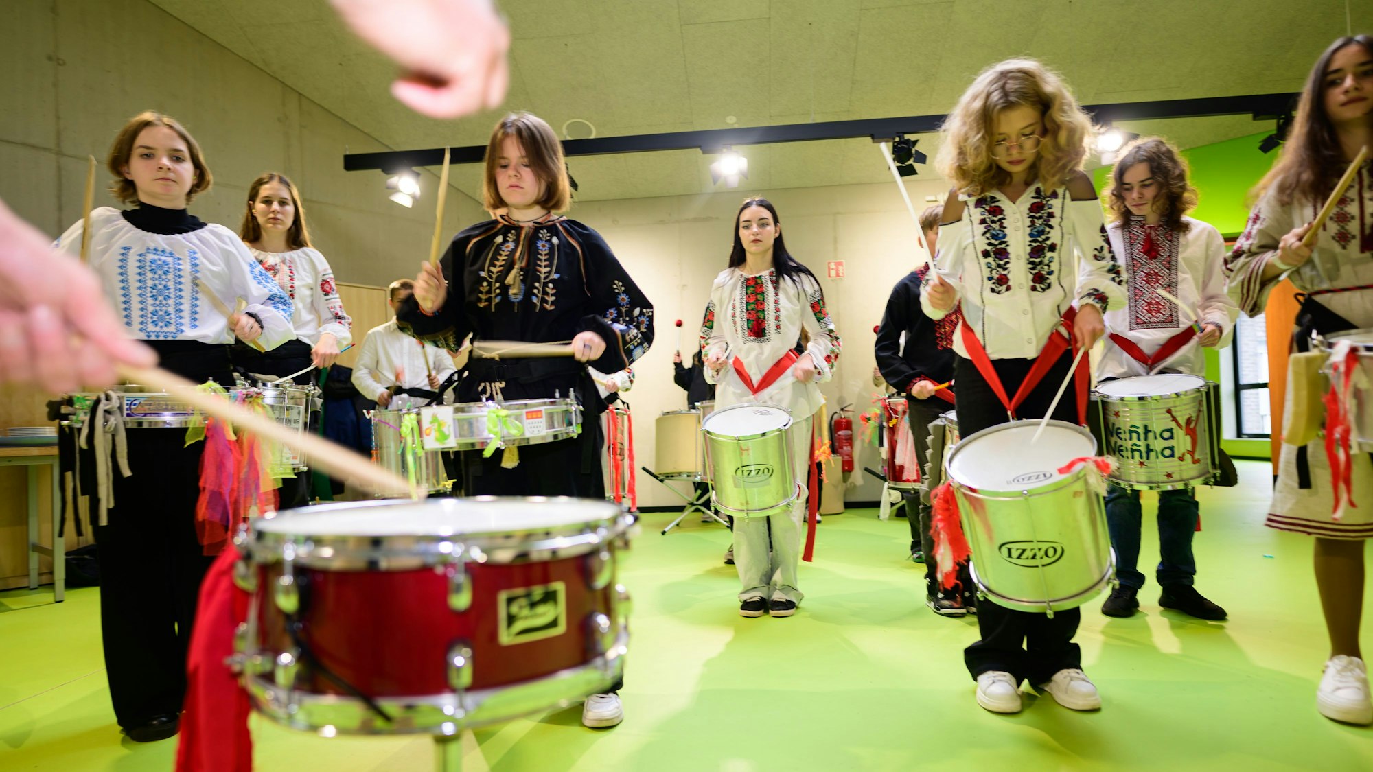 Schülerinne und Schüler klopfen auf Trommeln.