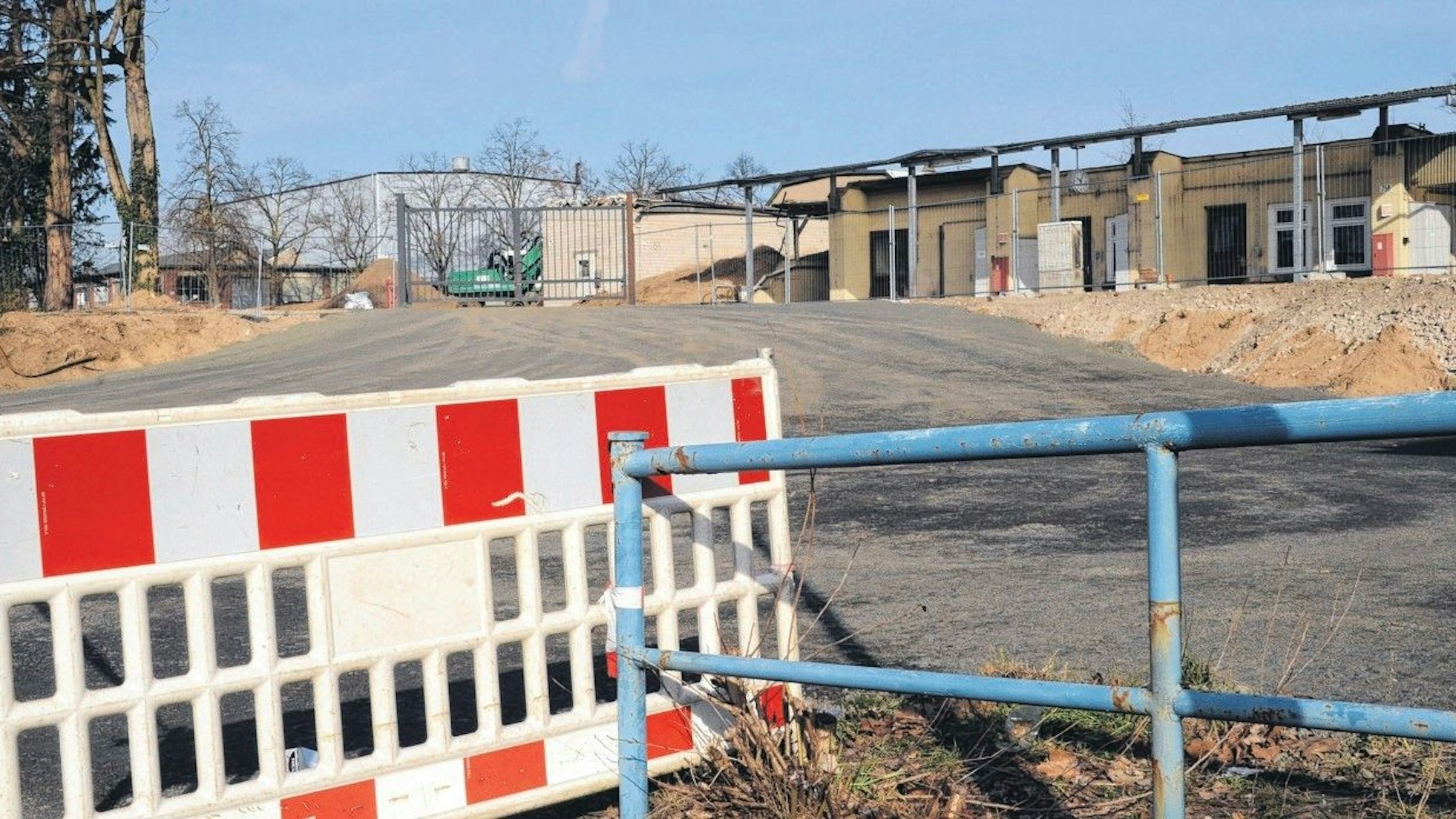 Eine rot-weiße Absperrung vor einem Industrie-Brachgrundstück.