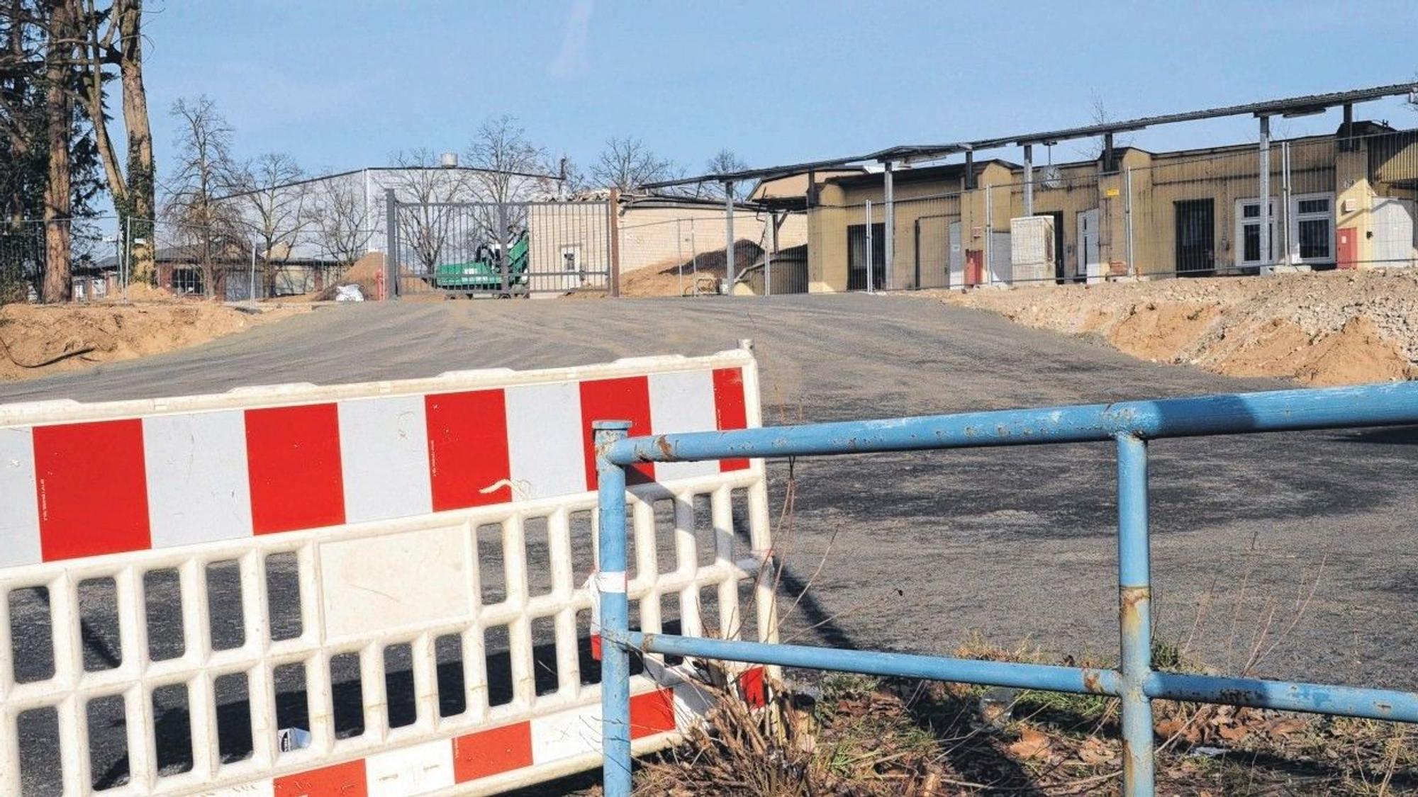 Eine rot-weiße Absperrung vor einem Industrie-Brachgrundstück.