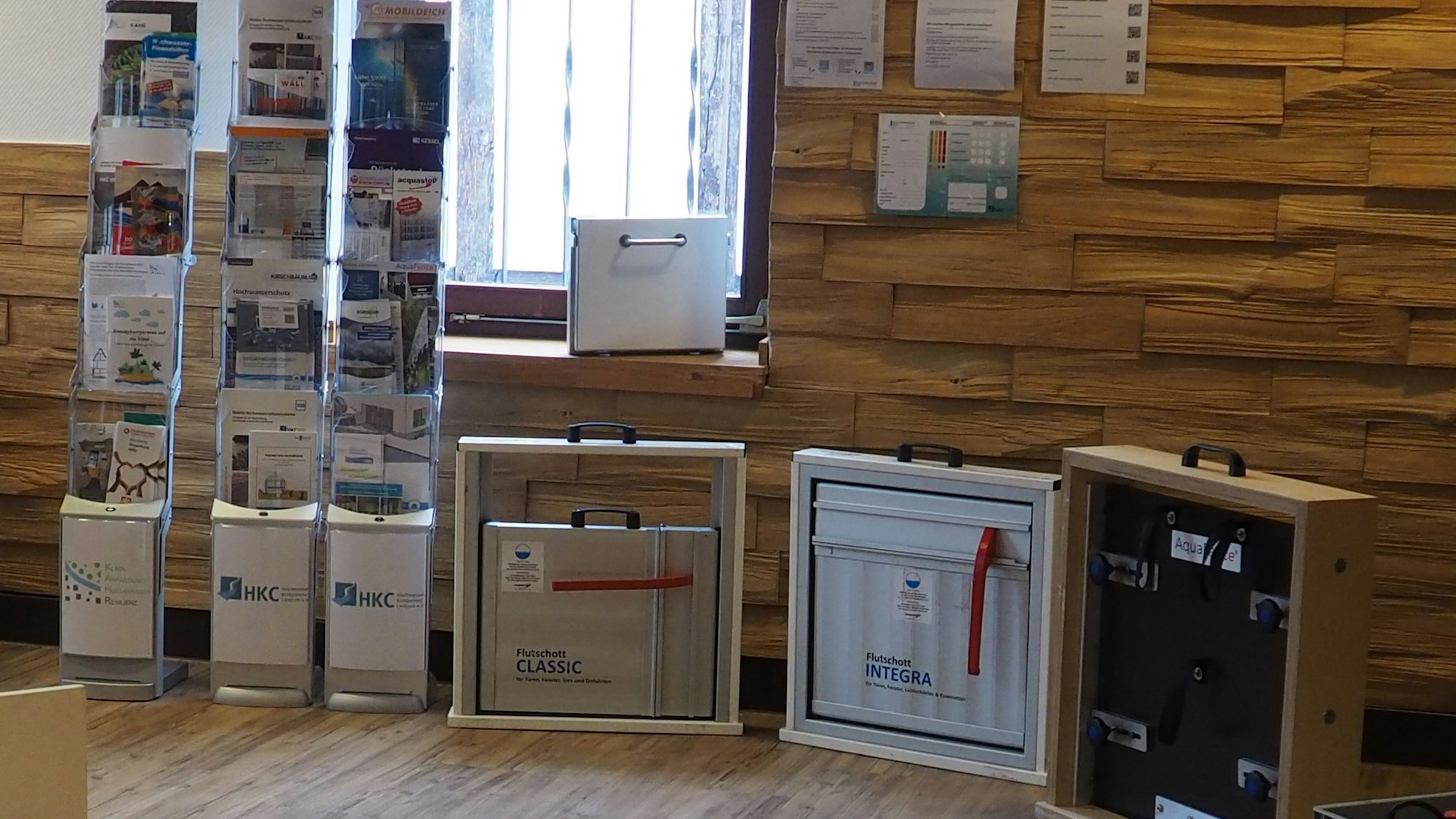 Links steht ein Ständer mit Informationsbroschüren, daneben sind technische Geräte aufgestellt.