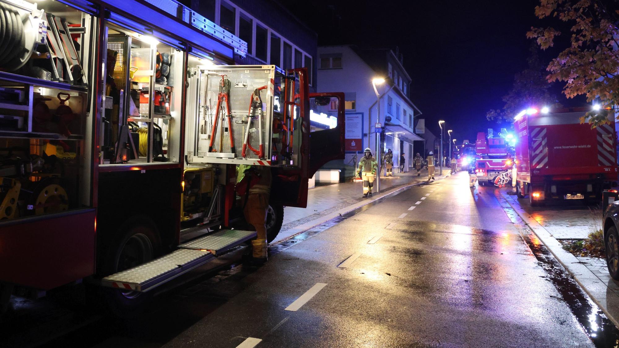 Auf der nächtlichen Bahnhofstraße stehen mehrere Feuerwehrautos.