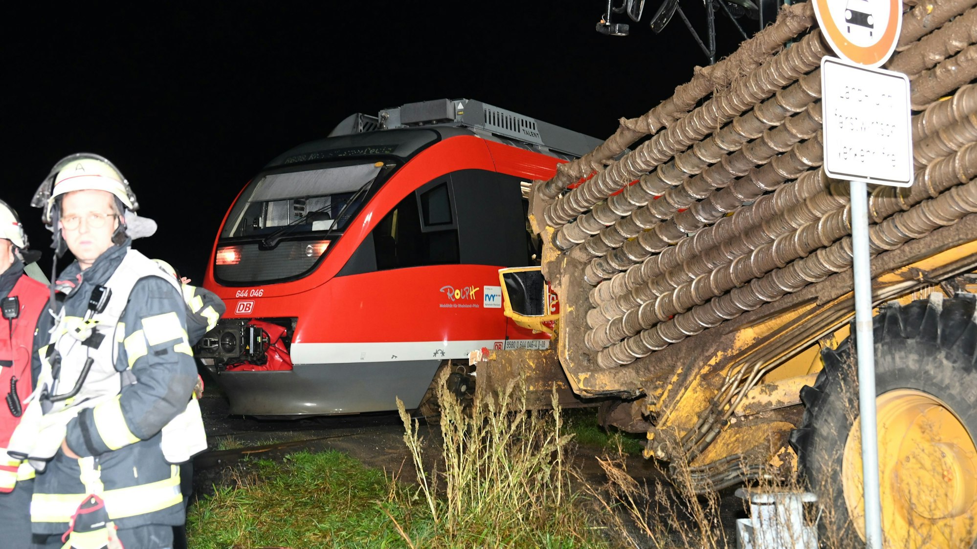 In Bergheim ist eine Regionalbahn mit einer Erntemaschine zusammengestoßen. Eine Feuerwehrfrau schaut in Richtung der Kamera, hinter ihr ist der Unfall zu sehen.