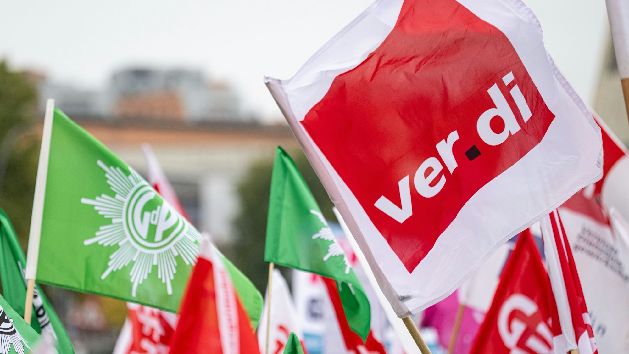 Verdi-Mitglieder demonstrieren vor dem Beginn der Tarifverhandlungen für den öffentlichen Dienst der Länder mit Flaggen, darunter einer der Gewerkschaft der Polizei (GdP) auf dem Scharounplatz.