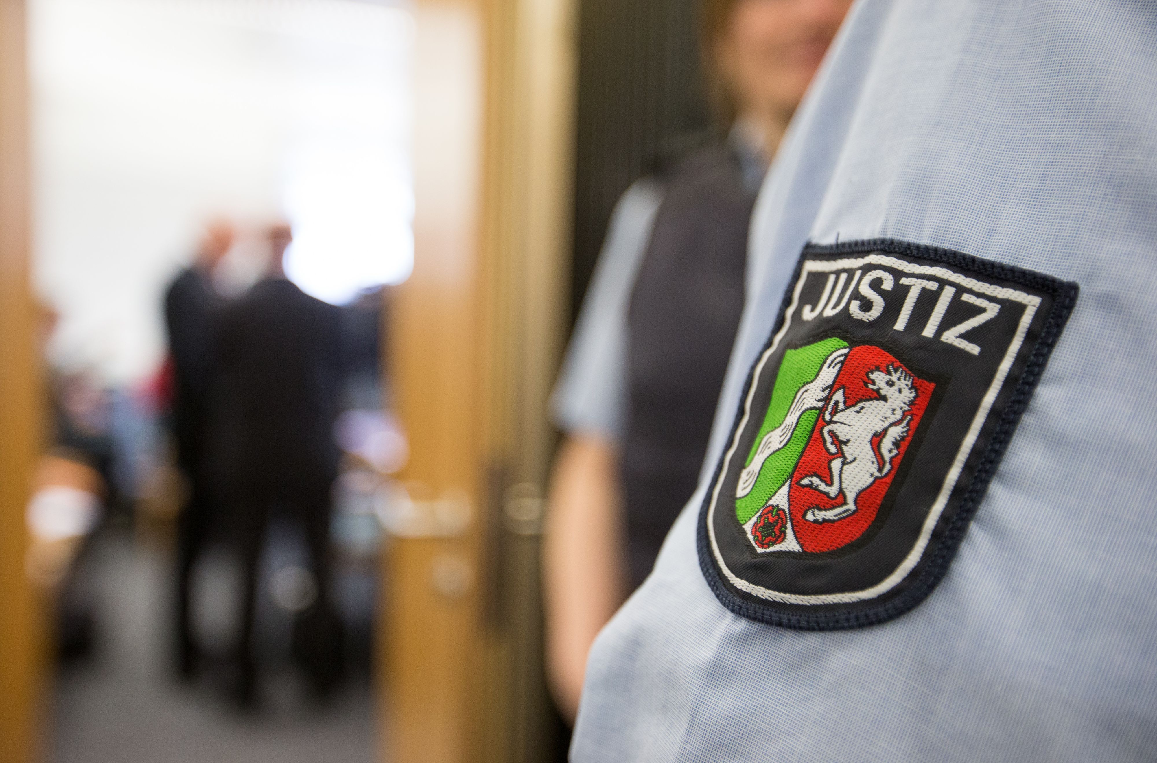 Ein Justizbeamter steht vor dem Sitzungssaal. (Symbolbild)