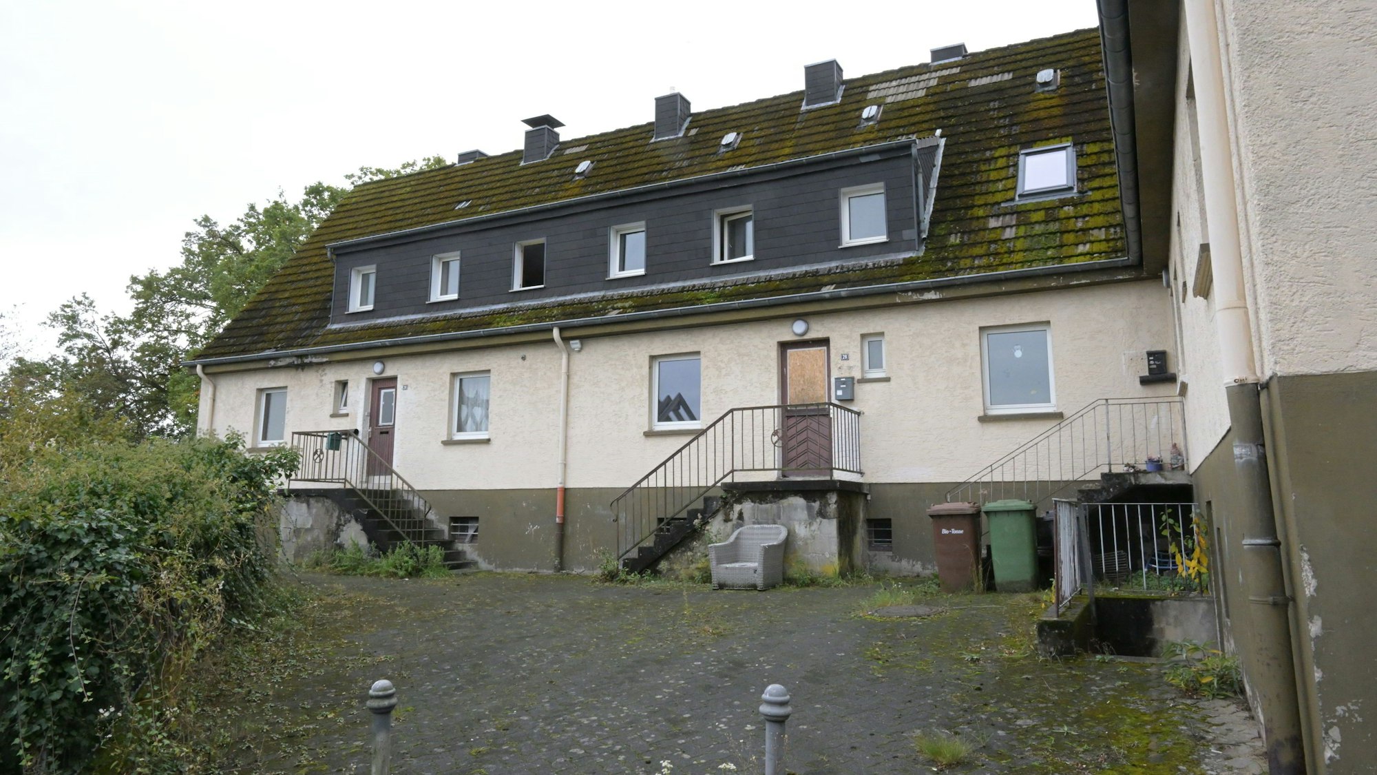 Ein Haus mit angegammeltem Äußeren steht verlassen in der Landschaft,