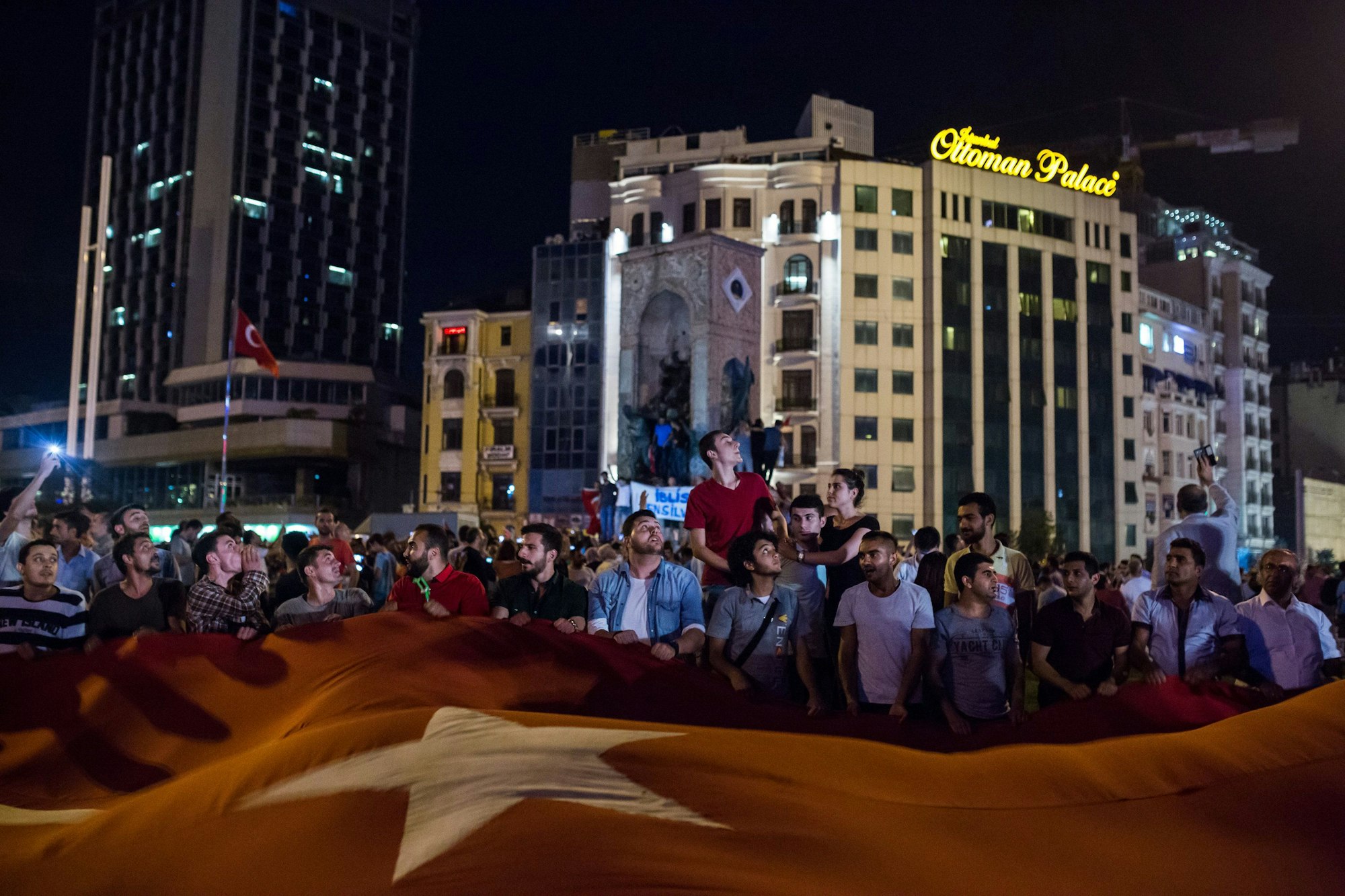 Anhänger des türkischen Präsidenten Erdogan halten am 16.07.2016 auf dem Taksim Platz in Istanbul, Türkei, eine riesige türkische Fahne. In der Nacht hatte das türkische Militär versucht, die Macht zu übernehmen.
