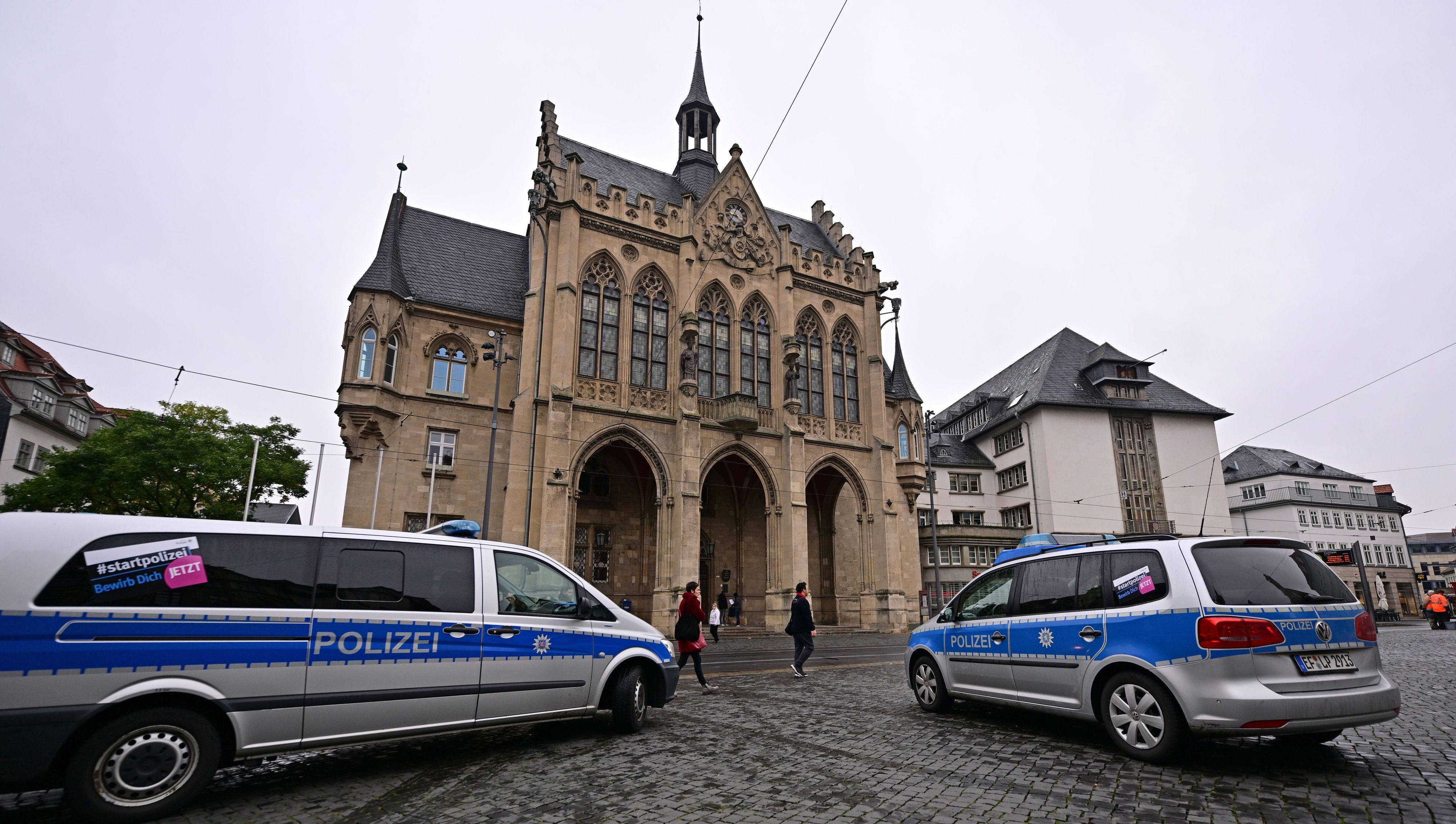 Polizeifahrzeuge stehen nach einer Bombendrohung vor dem Erfurter Rathaus.