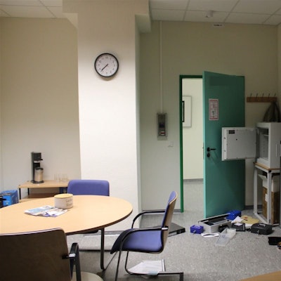 Ein Raum ist durchwühlt, eine Tresortür steht offen, auf dem Boden liegen Gegenstände verteilt.