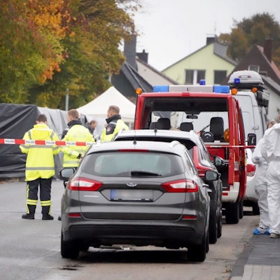 Ermittler stehen in einem von der Polizei abgesperrten Bereich, nachdem eine Leiche gefunden wurde.