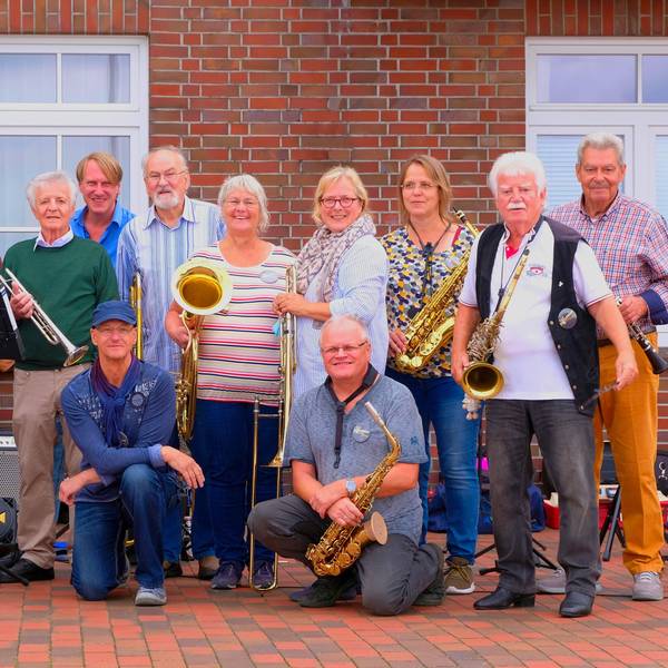 Die 14 Musiker posieren mit ihren Instrumenten