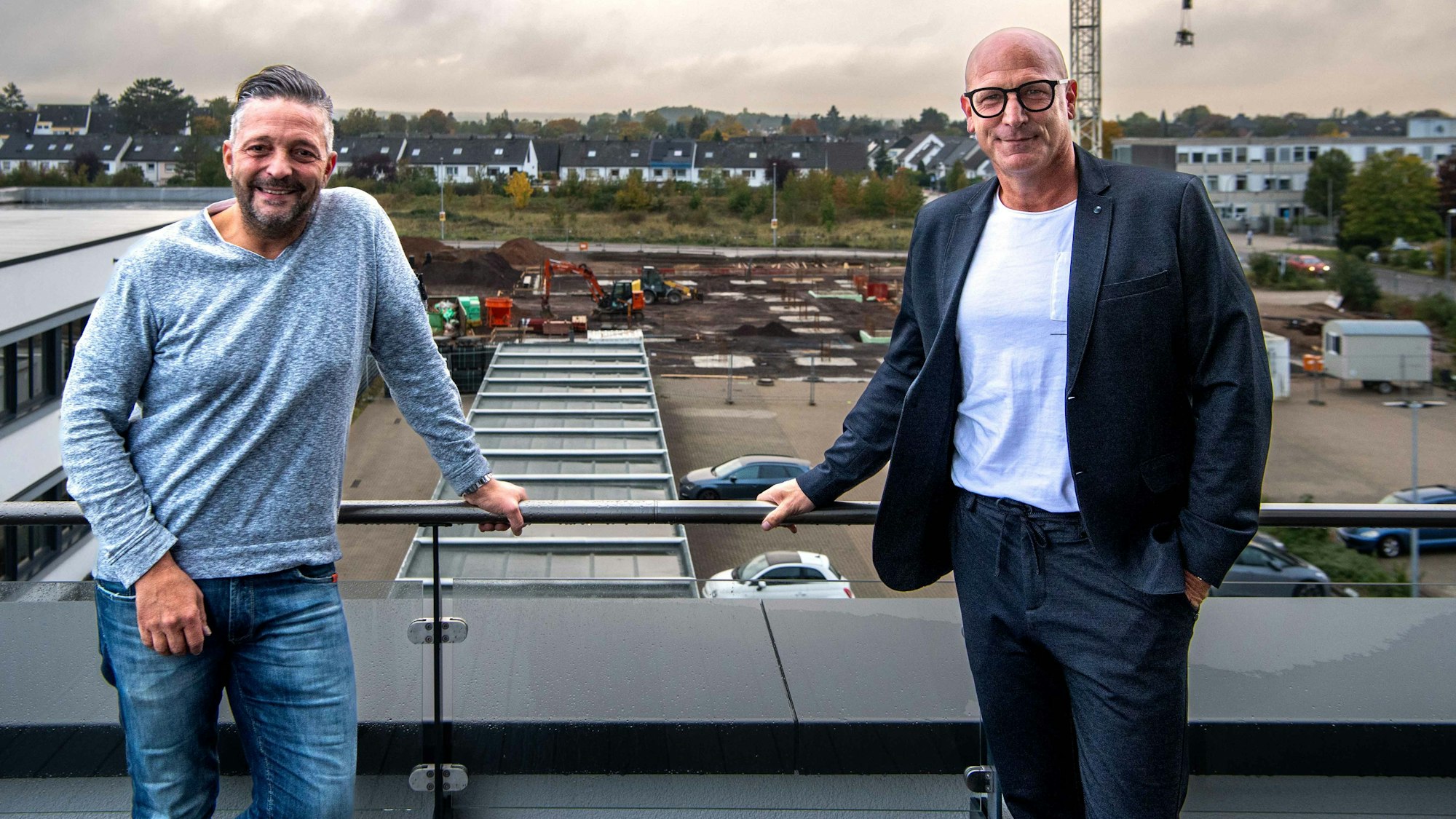 Das Bild zeigt Marcus Mahlberg und Claus Decker auf der Dachterrasse des Office Park I. Im Hintergrund ist die Baustelle des Folgeprojekts zu sehen.
