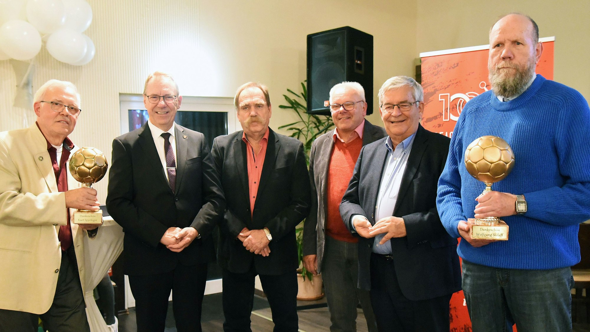 Foto einer Ehrung mit zwei goldenen Handbällen