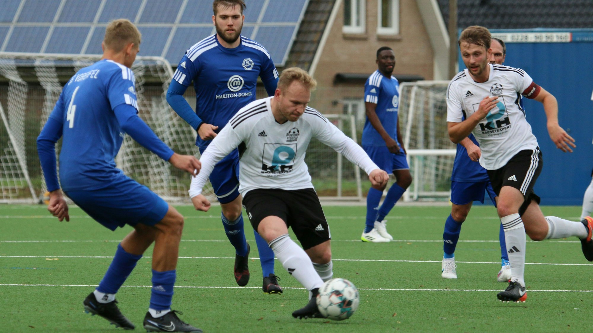 Nierfelds Sven Pohl passt, umzingelt von Gegenspielern, den Ball.