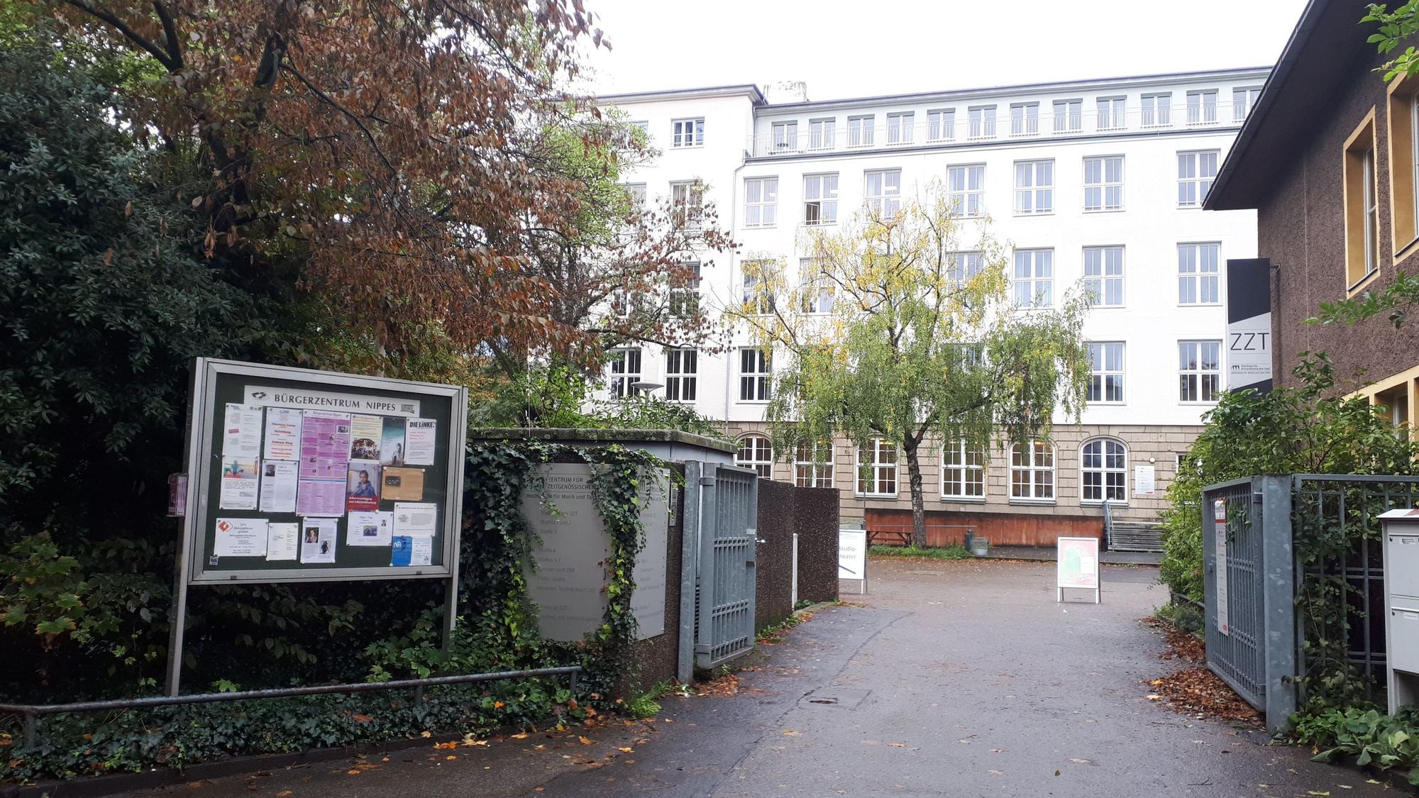 Das Tor zu einem Hof und einem großen Gebäude sind zu sehen.