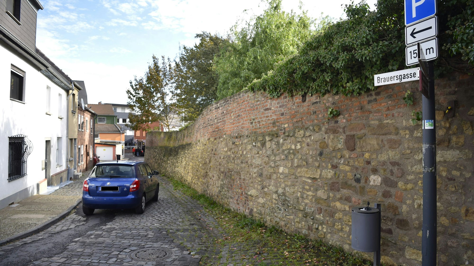 Blick in die Brauersgasse, in der ein blaues Auto fährt.