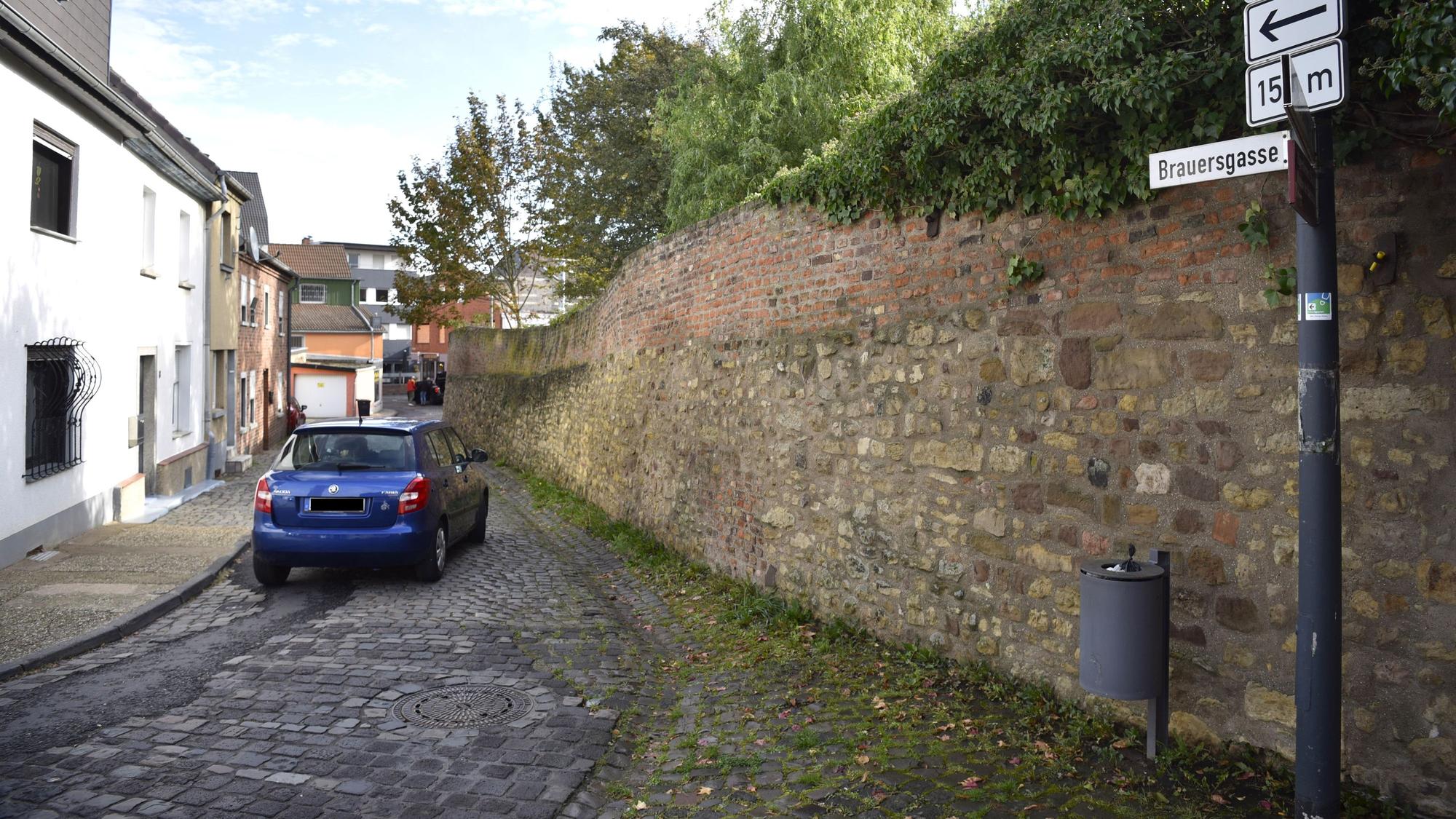 Das Bild zeigt ein blaues Auto, das die Brauersgasse entlang fährt.