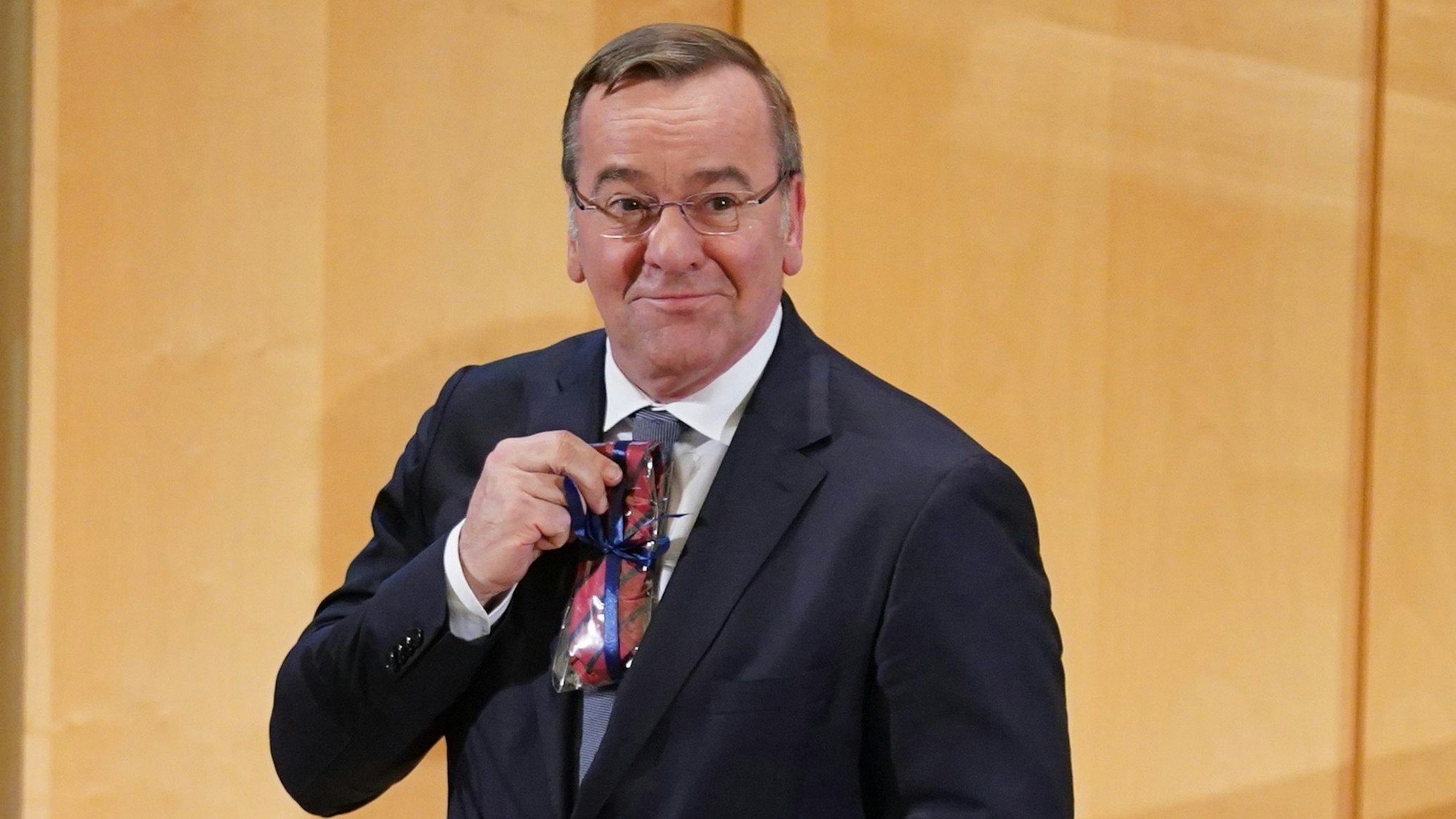 27.10.2023, Hamburg: Boris Pistorius (SPD), Bundesminister der Verteidigung, hält sein Geschenk, eine Krawatte der Bucerius Law School, nach seinem Besuch in der Bucerius Law School hoch. Zuvor hatte der Minister an einer Diskussionsveranstaltung zur Zeitenwende in der deutschen Außen- und Sicherheitspolitik teilgenommen. Foto: Marcus Brandt/dpa +++ dpa-Bildfunk +++