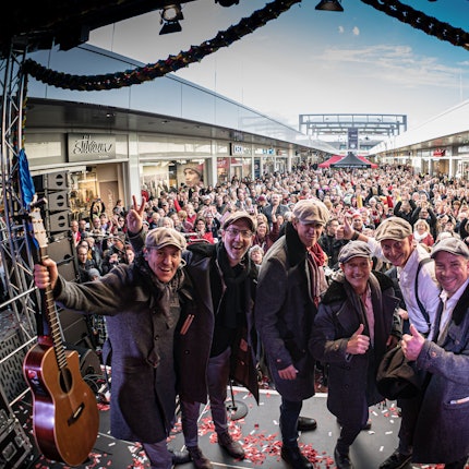 Eine Band auf der Bühne vor dem Publikum in der Ladenstraße des Einkaufszentrums Hürth-Park.