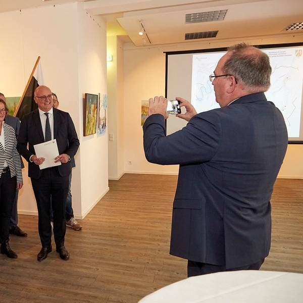 CDU-Landtagsmitglied Dr. Ralf Nolten macht ein Foto von Ministerin Ina Scharrenbach, Bürgermeister Jochen Weiler und Mitarbeitern der Verwaltung. Weiler hält den Bewilligungsbescheid in den Händen.