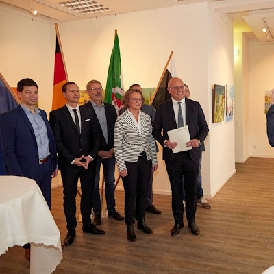 CDU-Landtagsmitglied Dr. Ralf Nolten macht ein Foto von Ministerin Ina Scharrenbach, Bürgermeister Jochen Weiler und Mitarbeitern der Verwaltung. Weiler hält den Bewilligungsbescheid in den Händen.